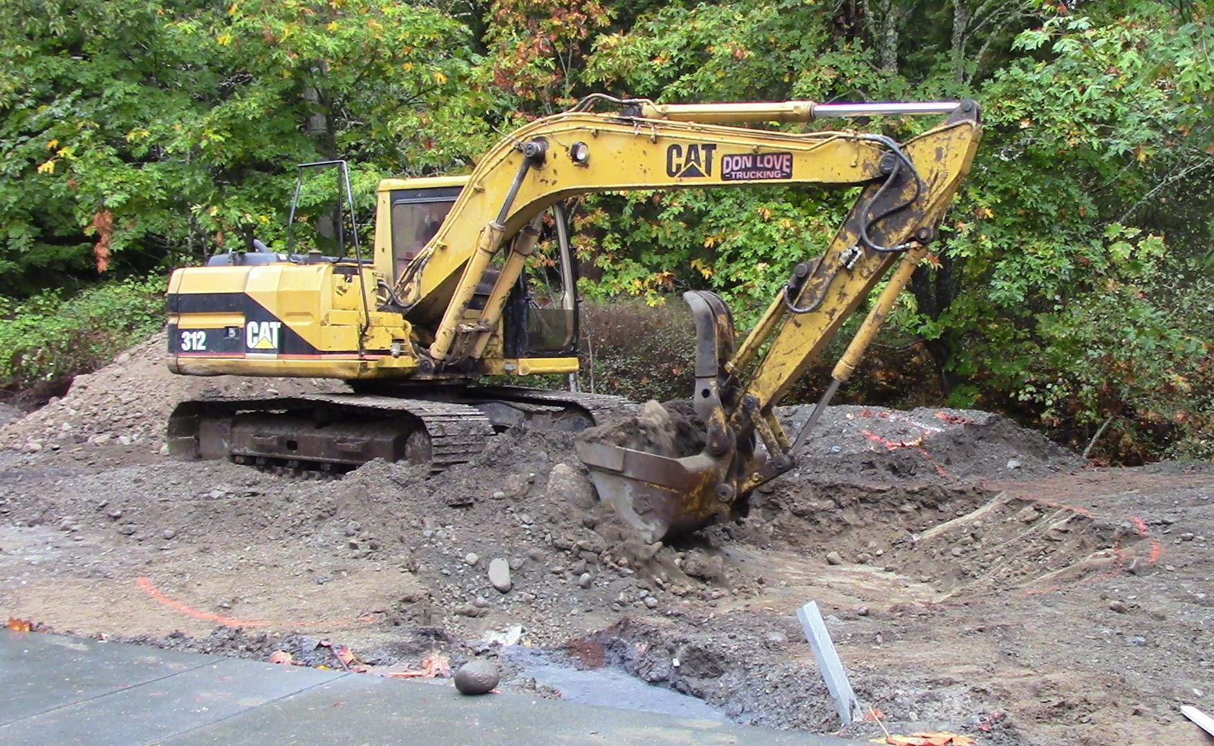 Excavator taking a shovel full of soil, digging the rain garden