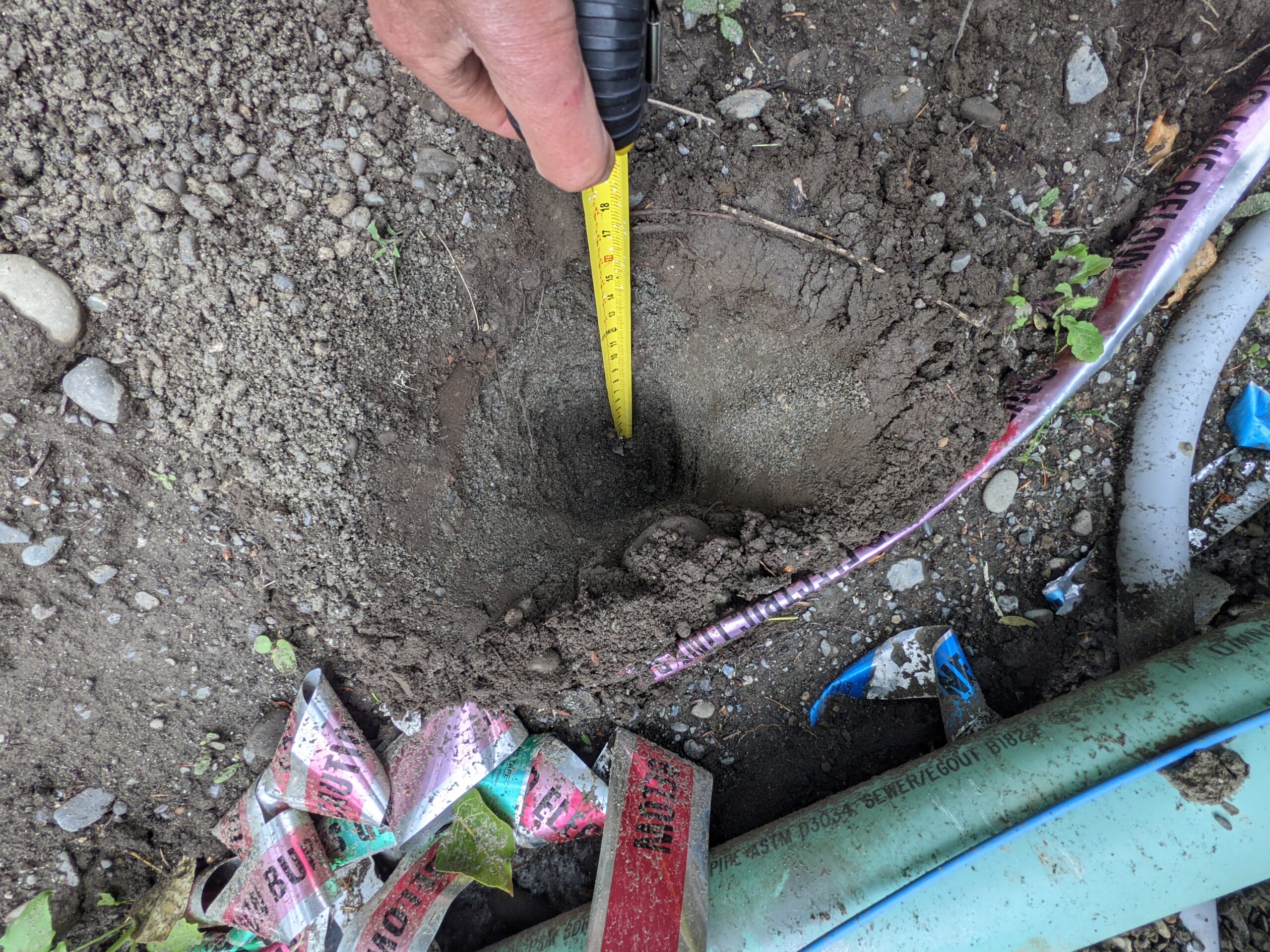 Measuring the depth of a perk hole to test for soil infiltration rate