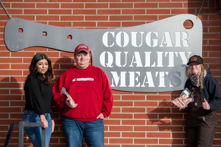 SSC members in front of Cougar Quality Meats sign