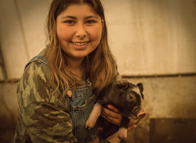 Seniah Flesher with a piglet
