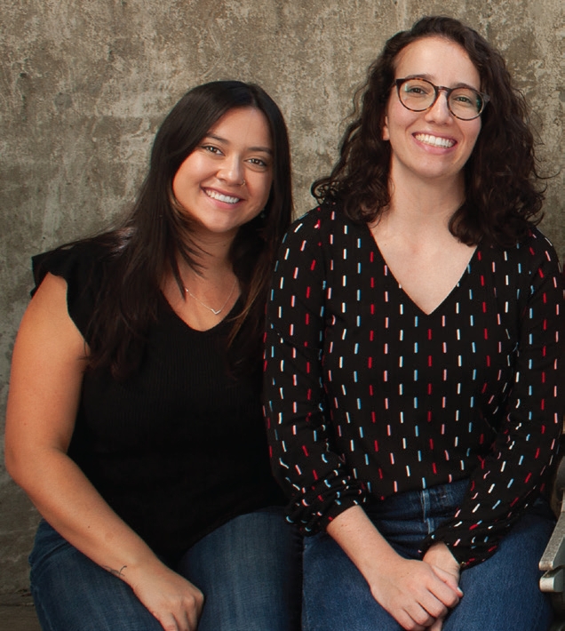 Two students posing for photo with plain background
