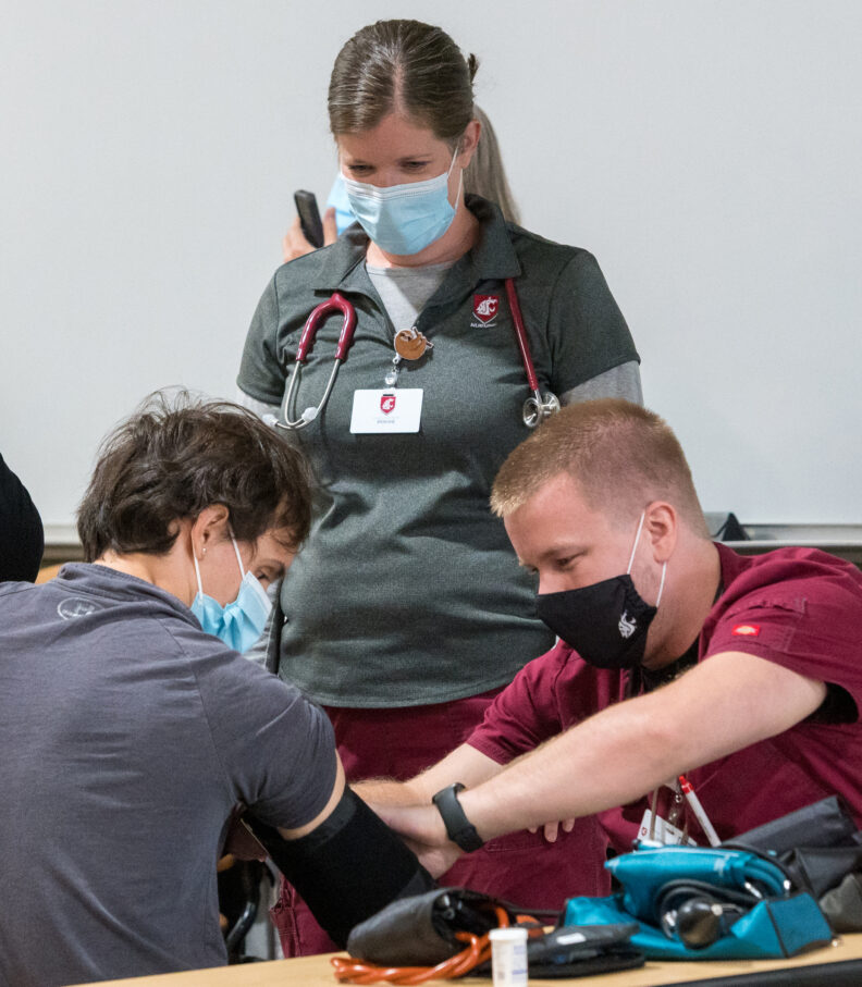 nursing students in crimson and gray scrubs