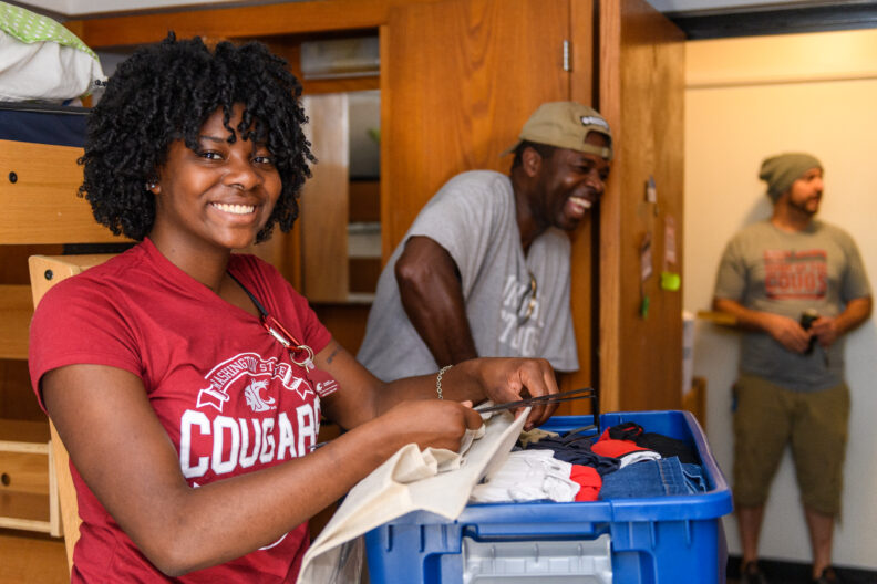Student smiles and unpacks for overnight at orientation
