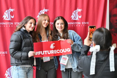 Students holding a #FutureCoug sign while attending Experience WSU.