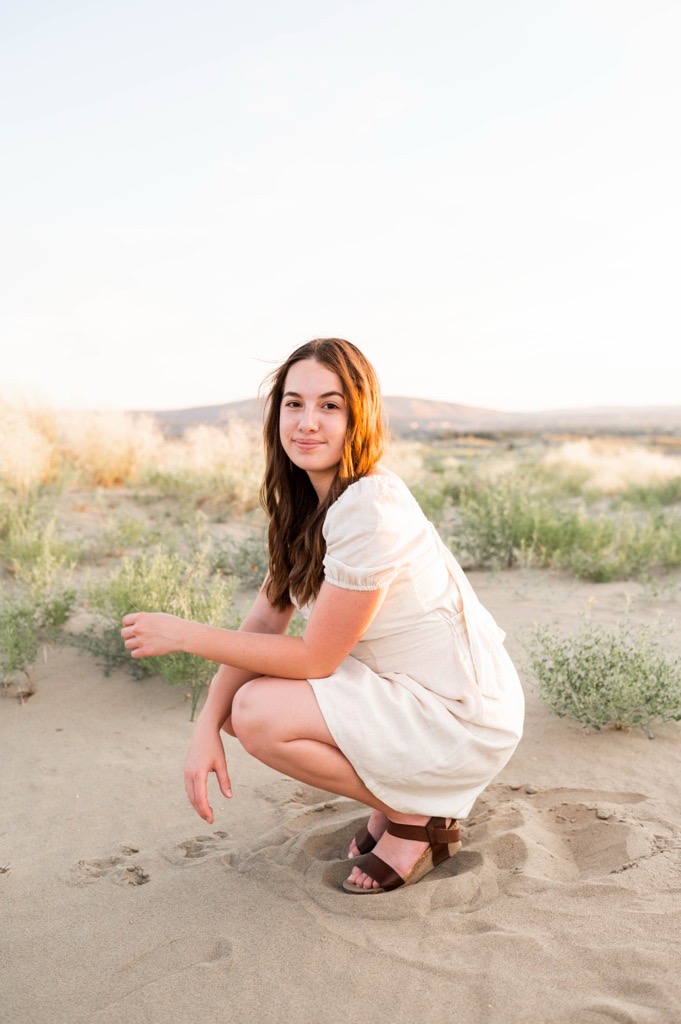 OL Cecily crouches down to look at the camera at golden hour