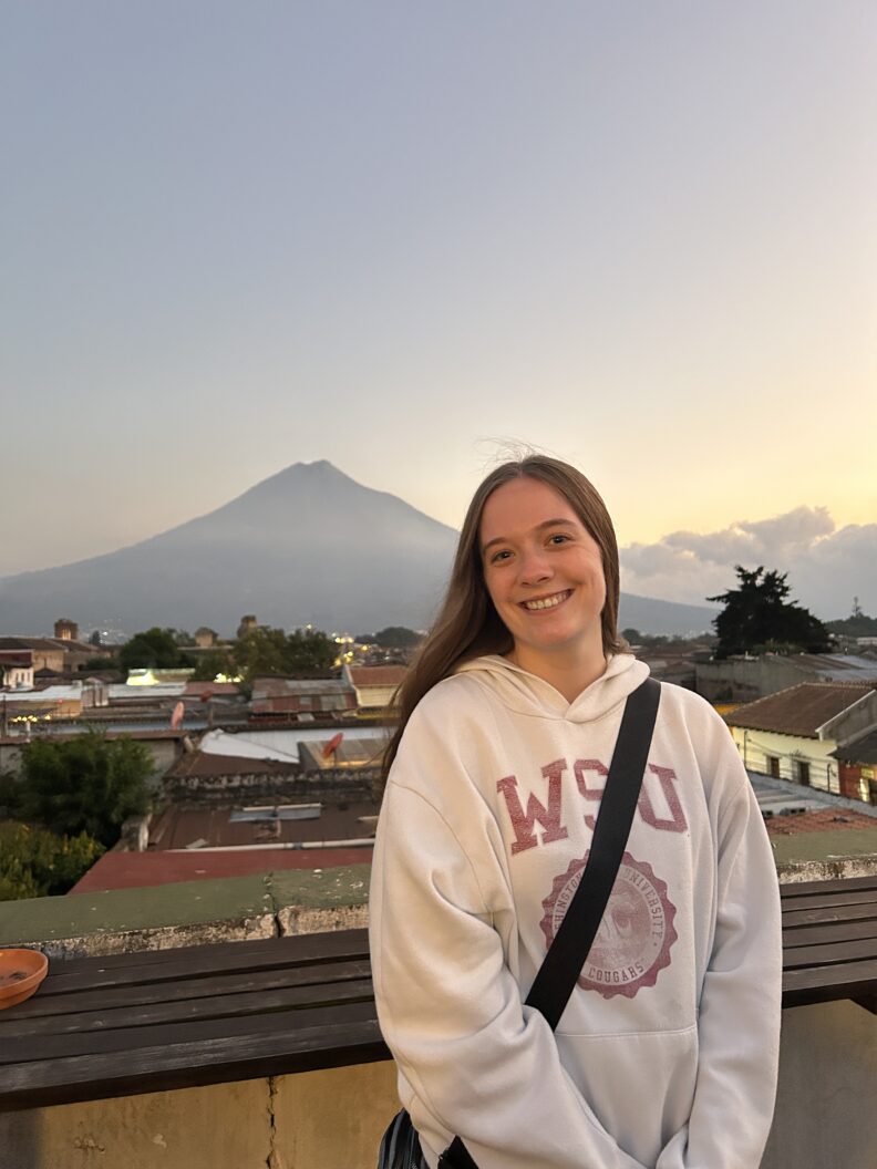 OL Lauren smiling at golden hour with a mountain in the background.