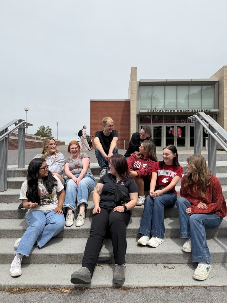 Nine OL's sit on the CUB steps chatting and laughing on a sunny day.