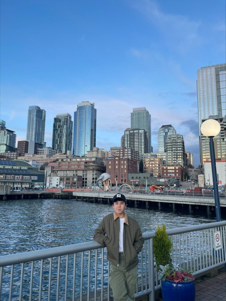 OL Silvano stands on a bridge with a beautiful cityscape in the background.