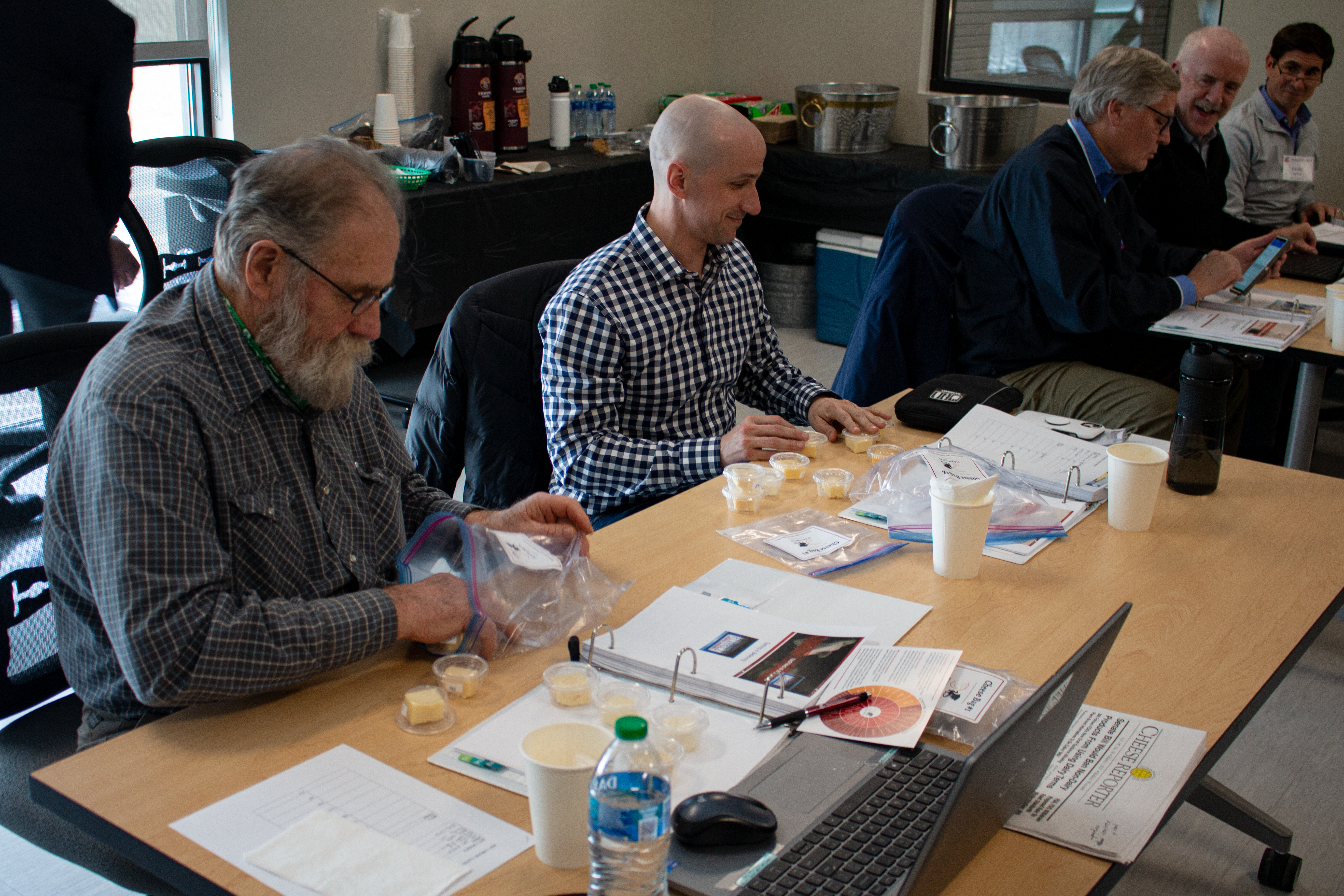 A photo of two people looking at samples of cheese.