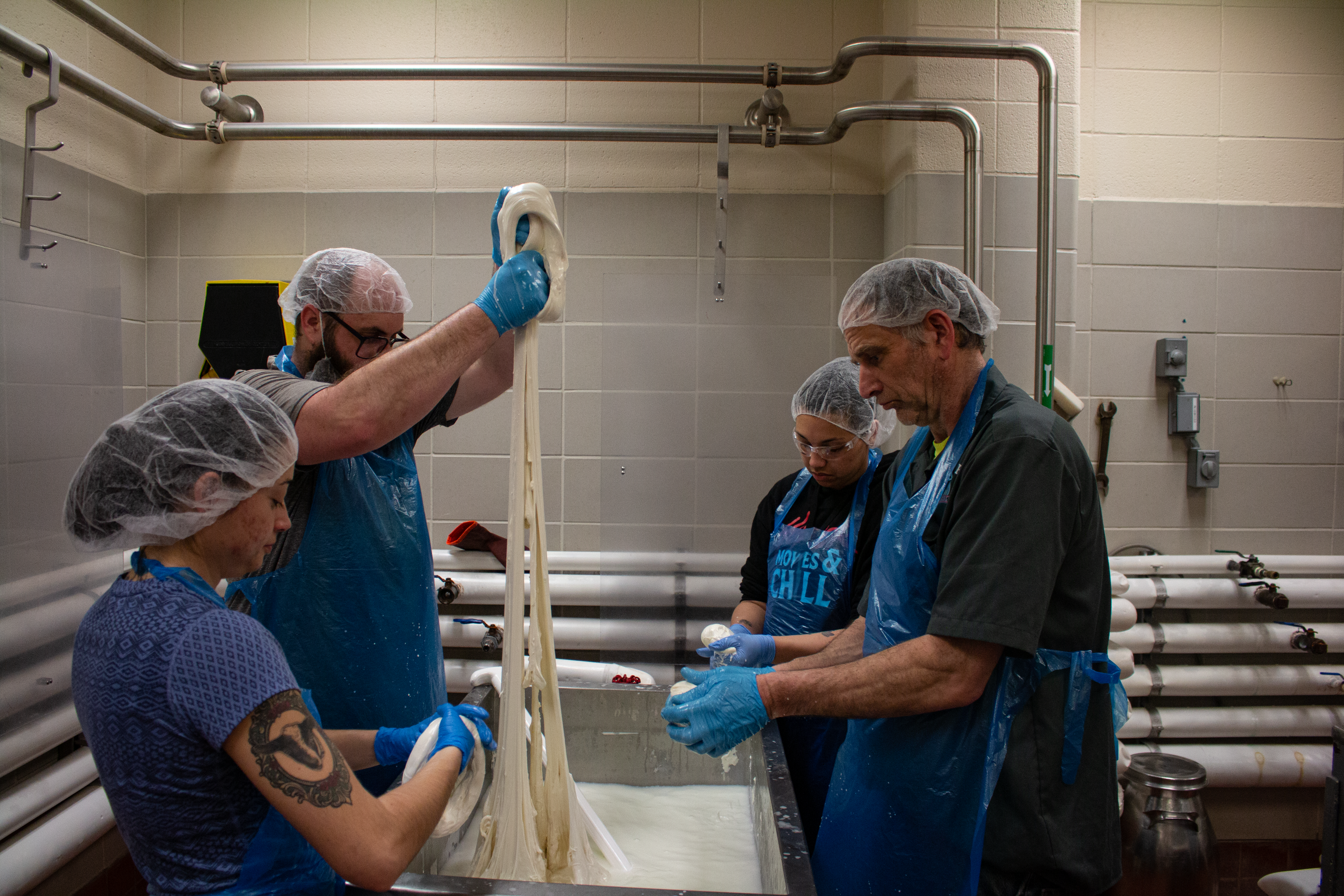 A photo of people stretching cheese.
