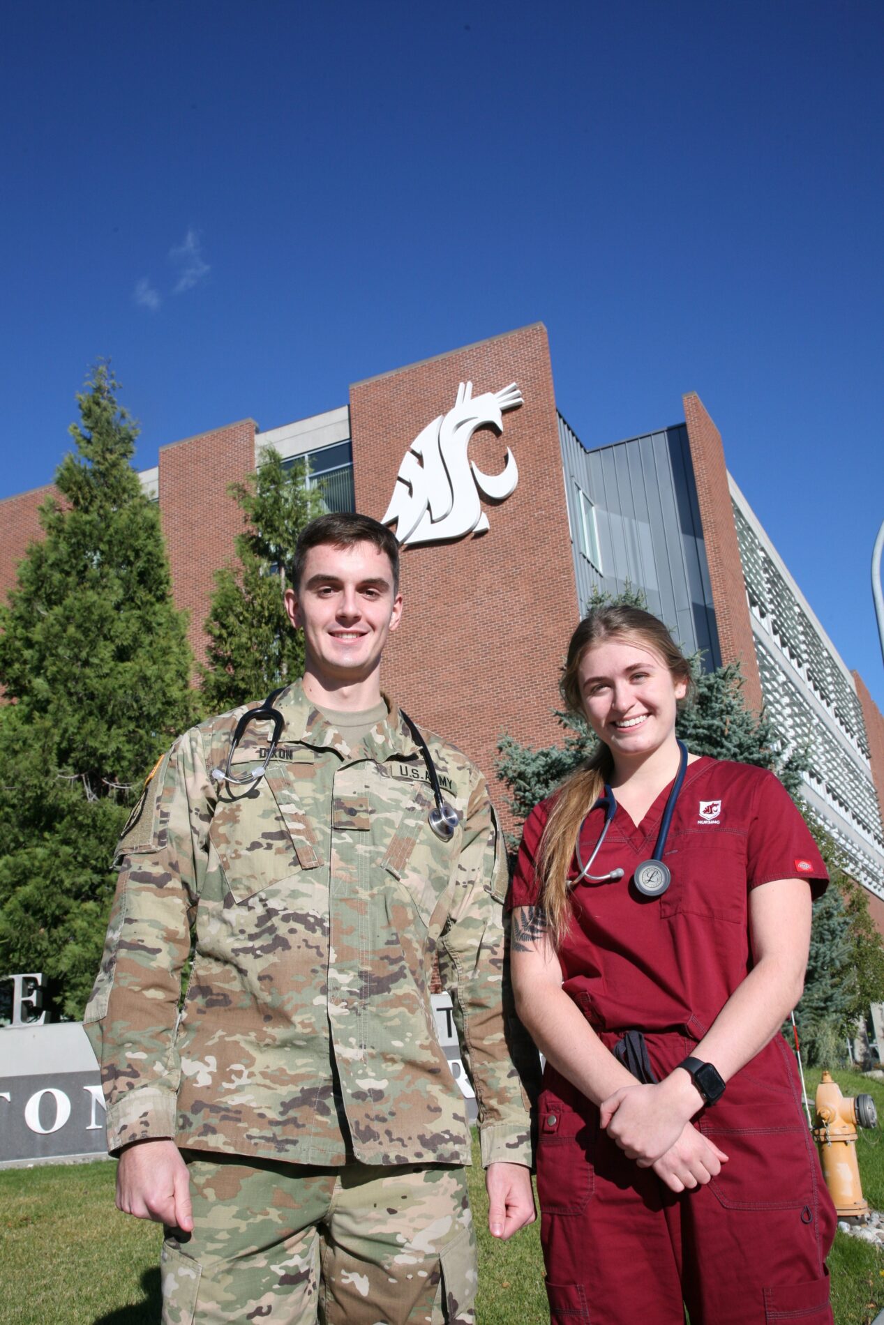 Two WSU nursing ROTC students in front of the College of Nursing building.