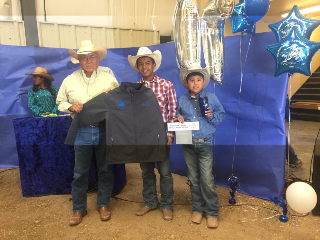 Man and two children standing behind a table at fair