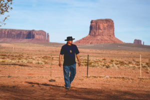 Handsome and rugged traditional Navajo Man portrait outside in Monument Valley Arizona with scenery view