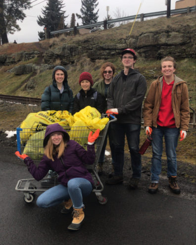 6 students participating in a river cleanup.