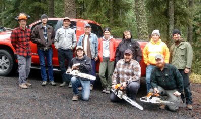 Group of people in forest with chainsaws