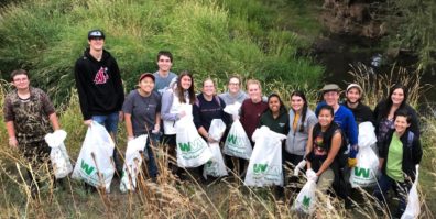 Group of students with trash bags at river