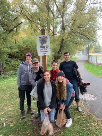 Group of students in front of sign that reads adopt a stream