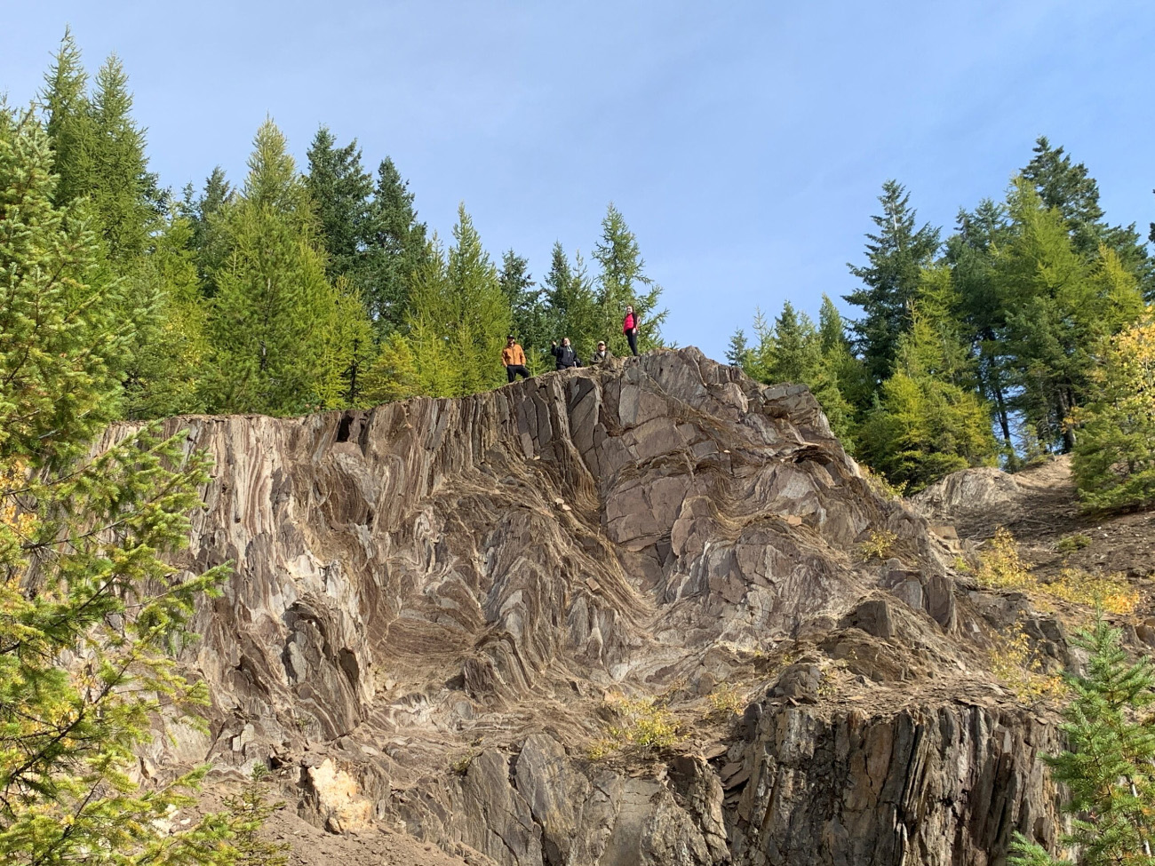 Geologists standing atop an interesting rock formation.