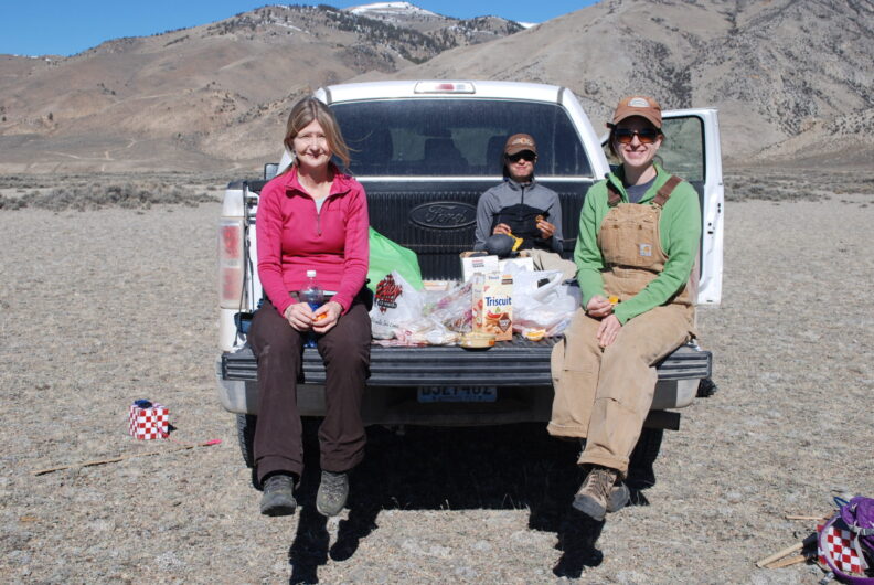 Field researchers taking a break on the bed of a truck.
