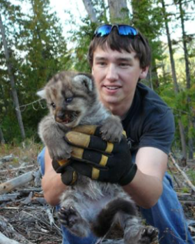 Geology student holding a young cub.