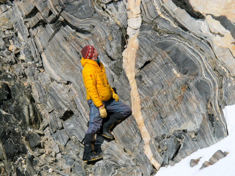 Student examining rock strata in the field.