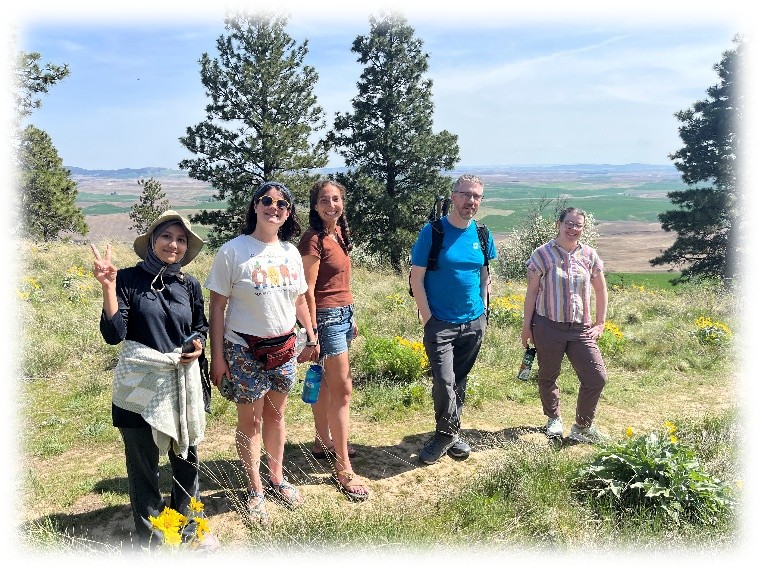 Five students at the top of Kamiak Butte overlooking the Palouse hills