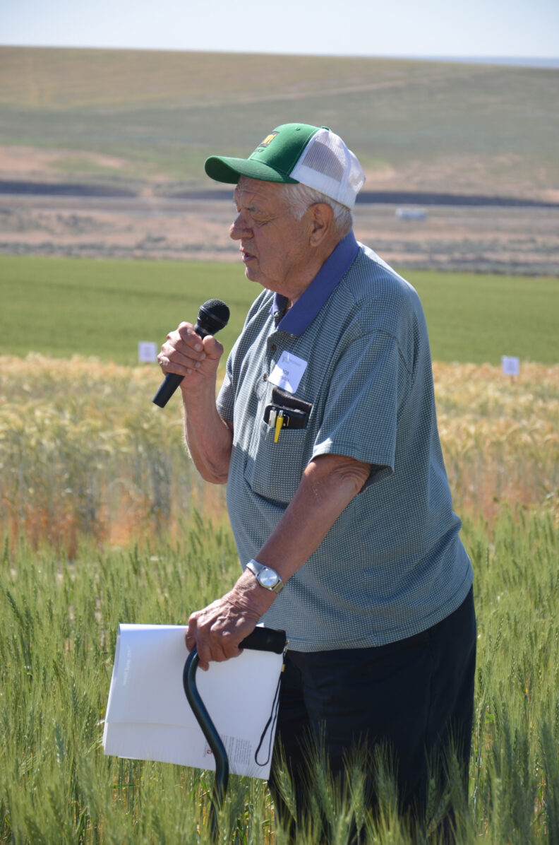 Bob Papendick speaking in a field.