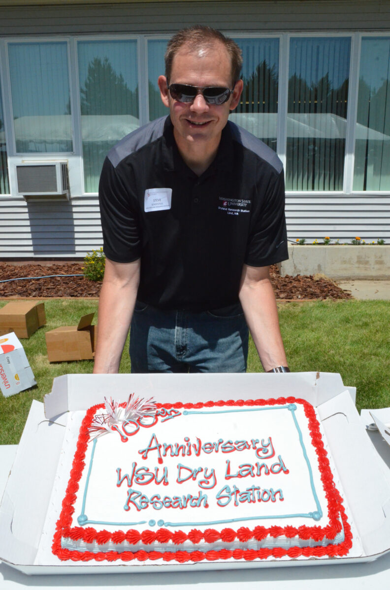 Steve Schofstoll holding up a cake.