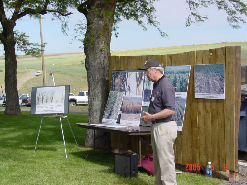 Man standing next to a poster.