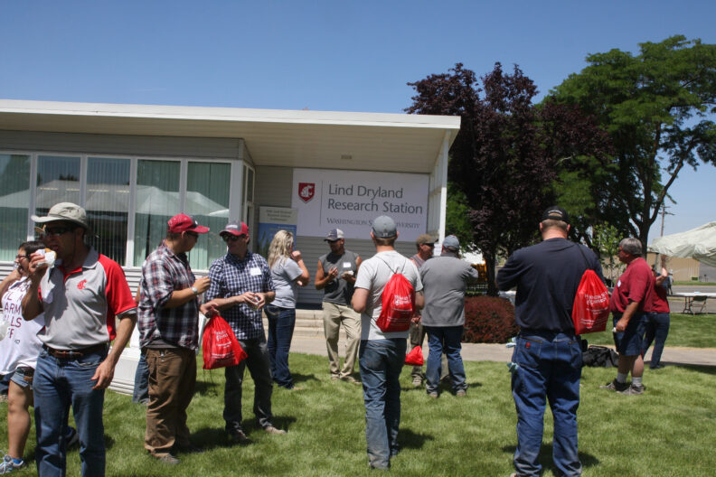 People standing around the yard during the ice cream social.