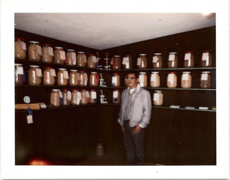 Man standing in front of jars of wheat.