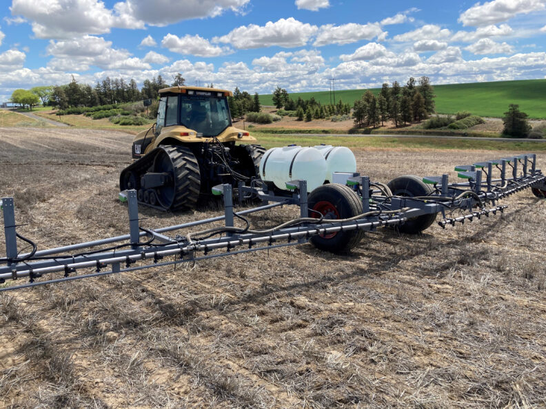 Weed-It sprayer pulled behind a tractor.