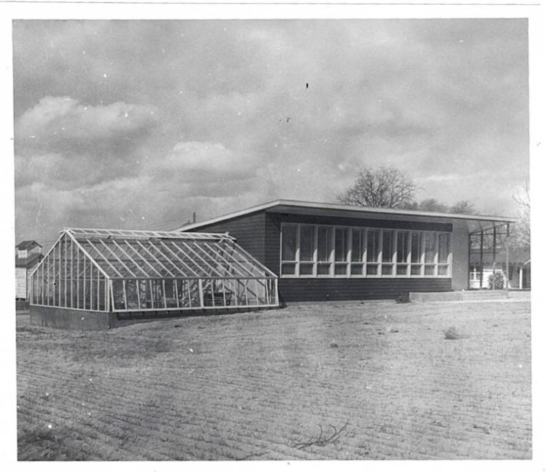 Office and greenhouse with dirt in front.