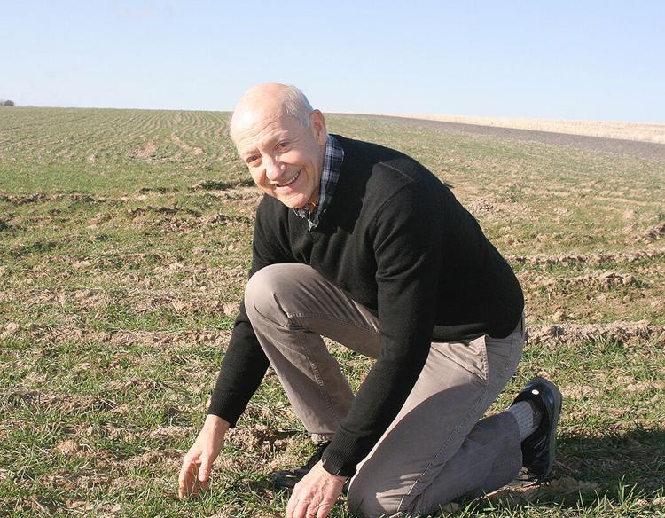 Bill kneeling in a field.