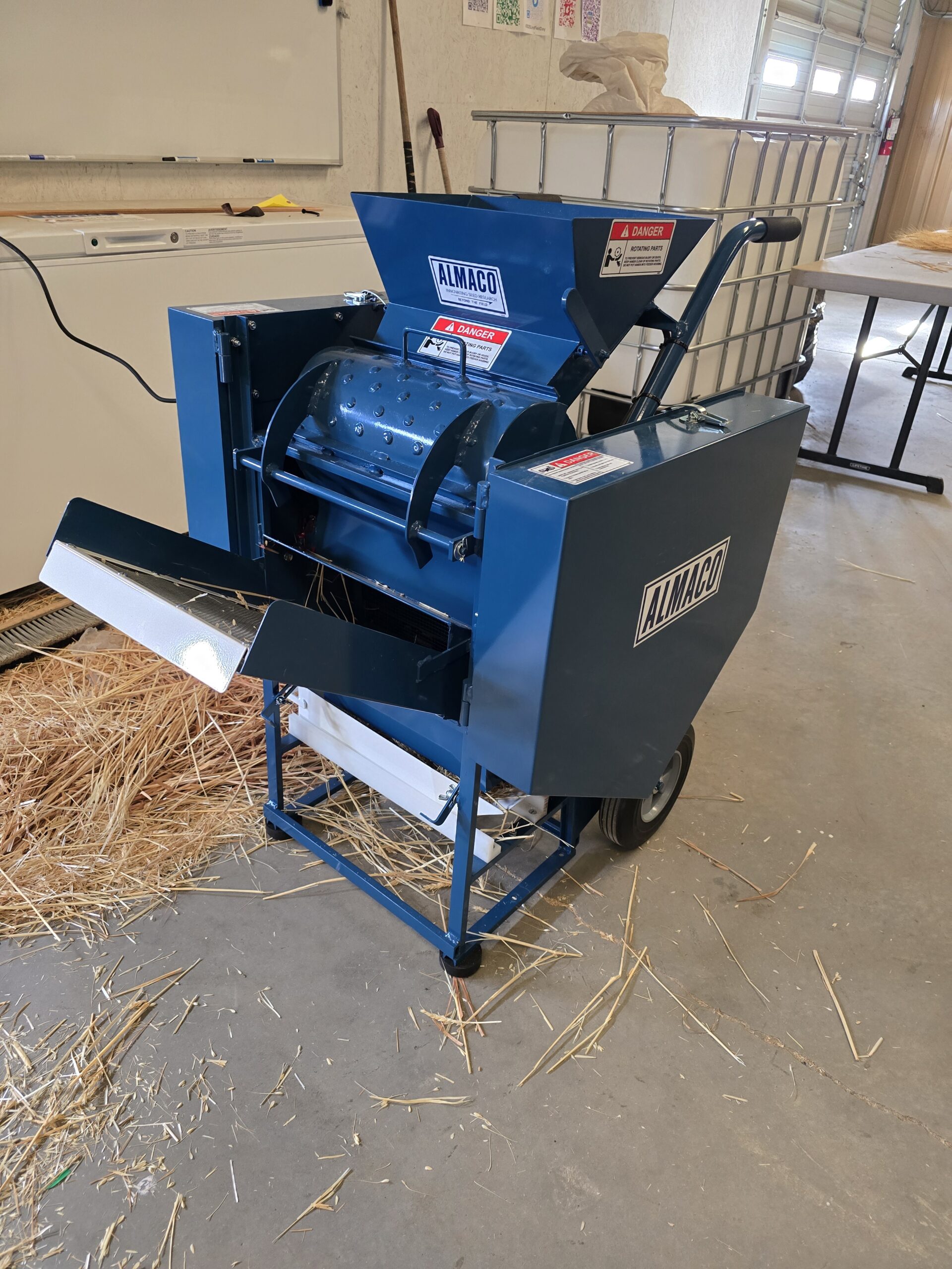 Thresher with wheat chaff in the background.