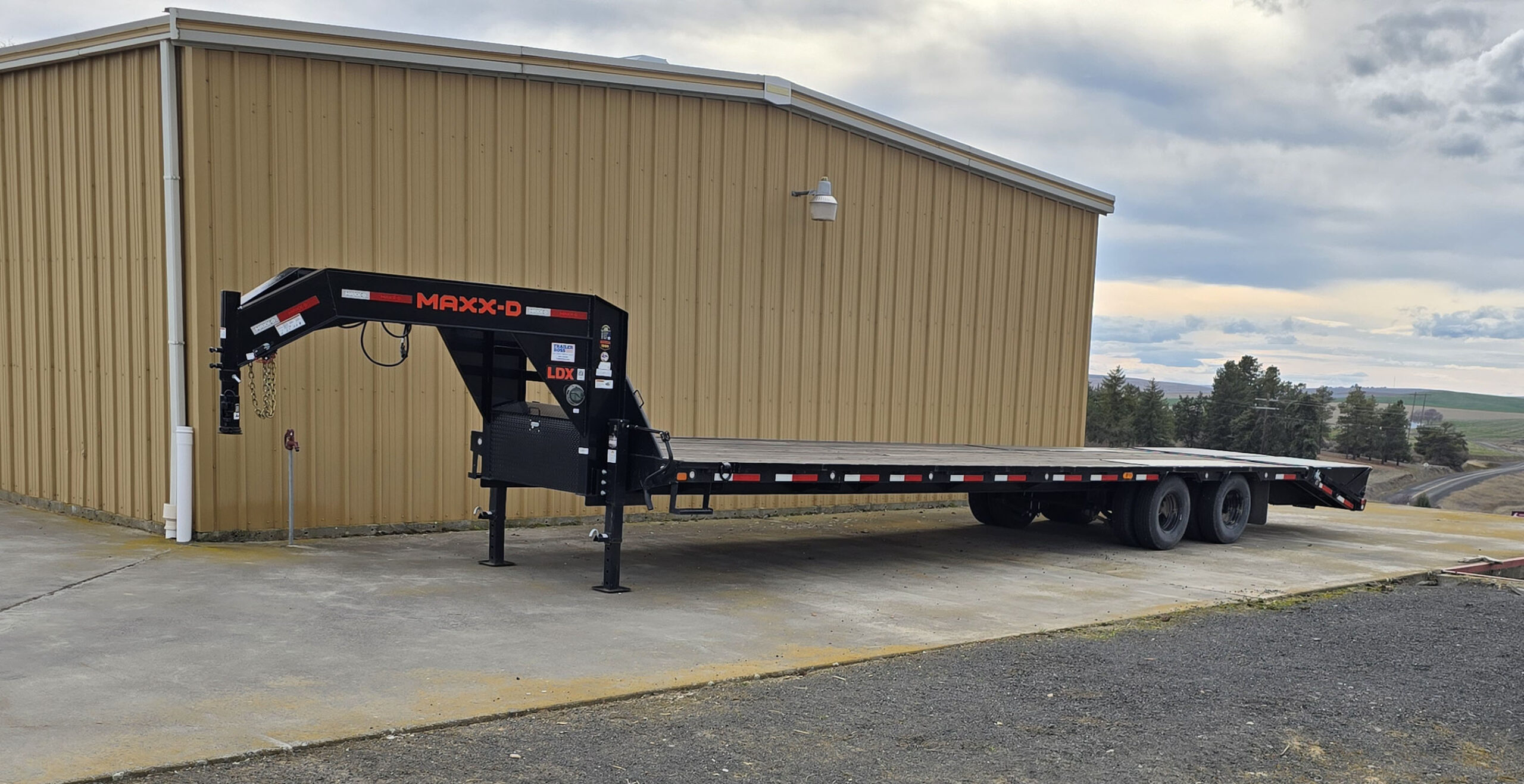Gooseneck trailer next to a building.