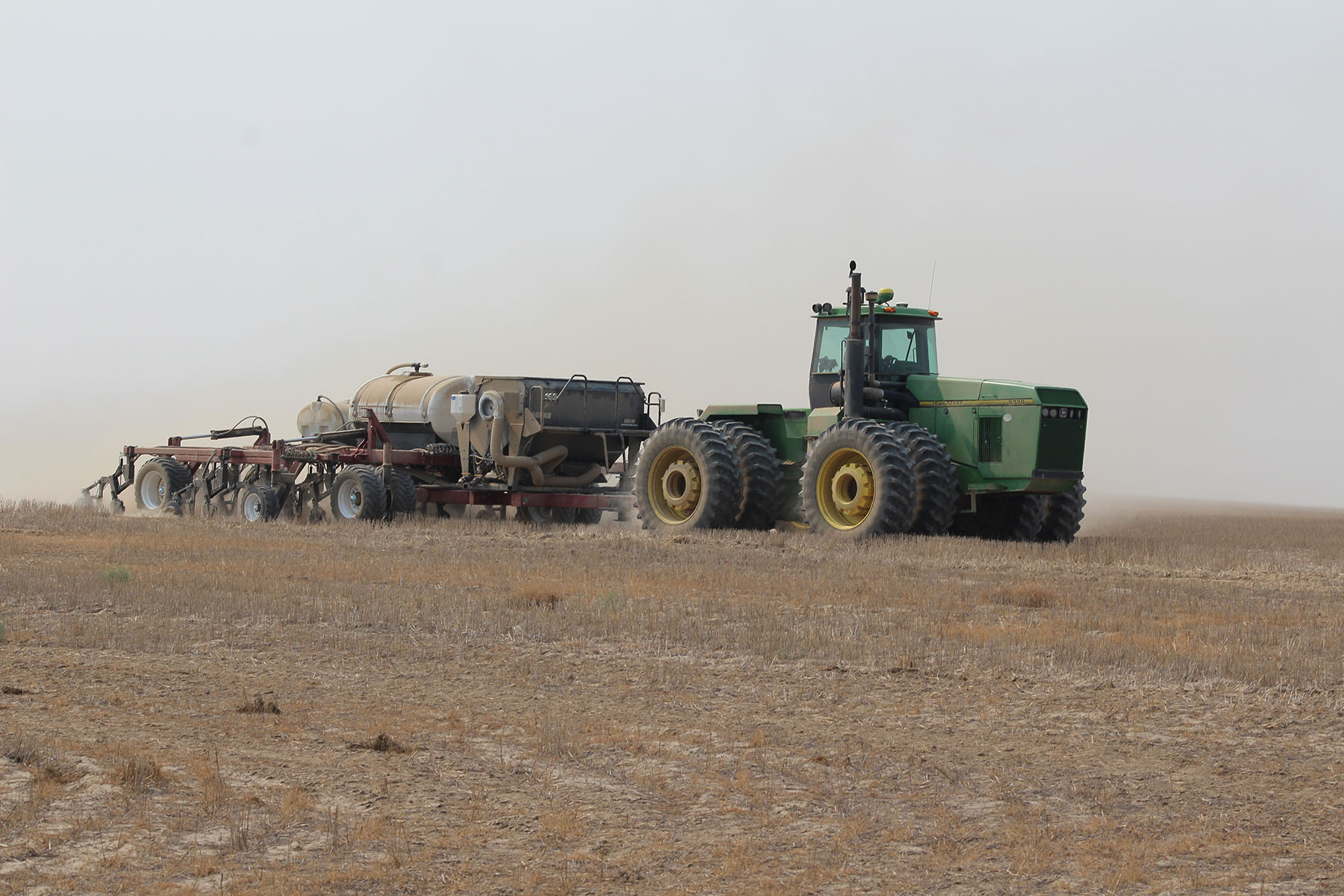Tractor pulling a drill in a field.
