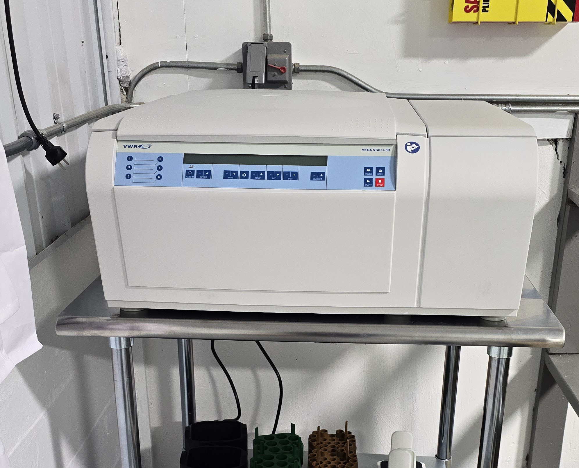 Centrifuge on a table with adapters below.