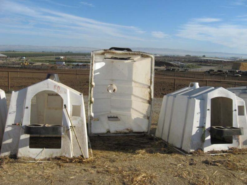 Three empty hutches, one tipped on its end.