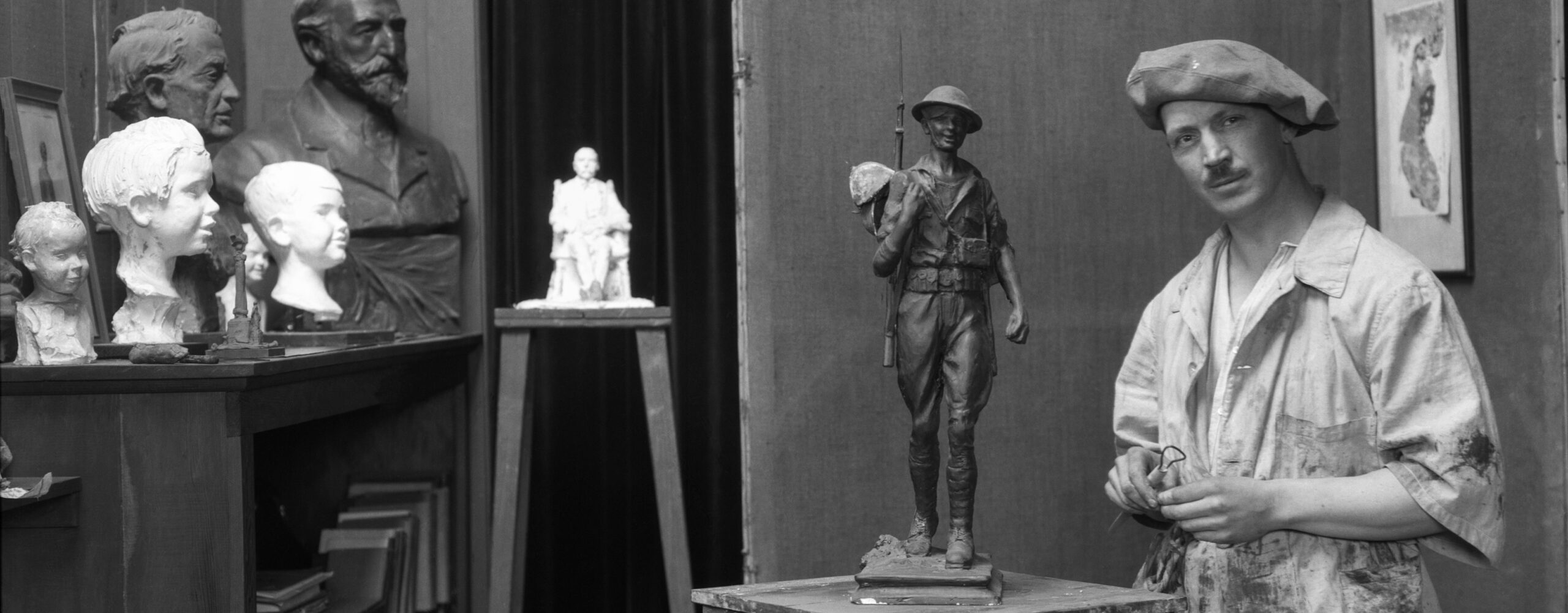 Picture of artist Alonzo Victor Lewis in studio, including several busts and a model military statue