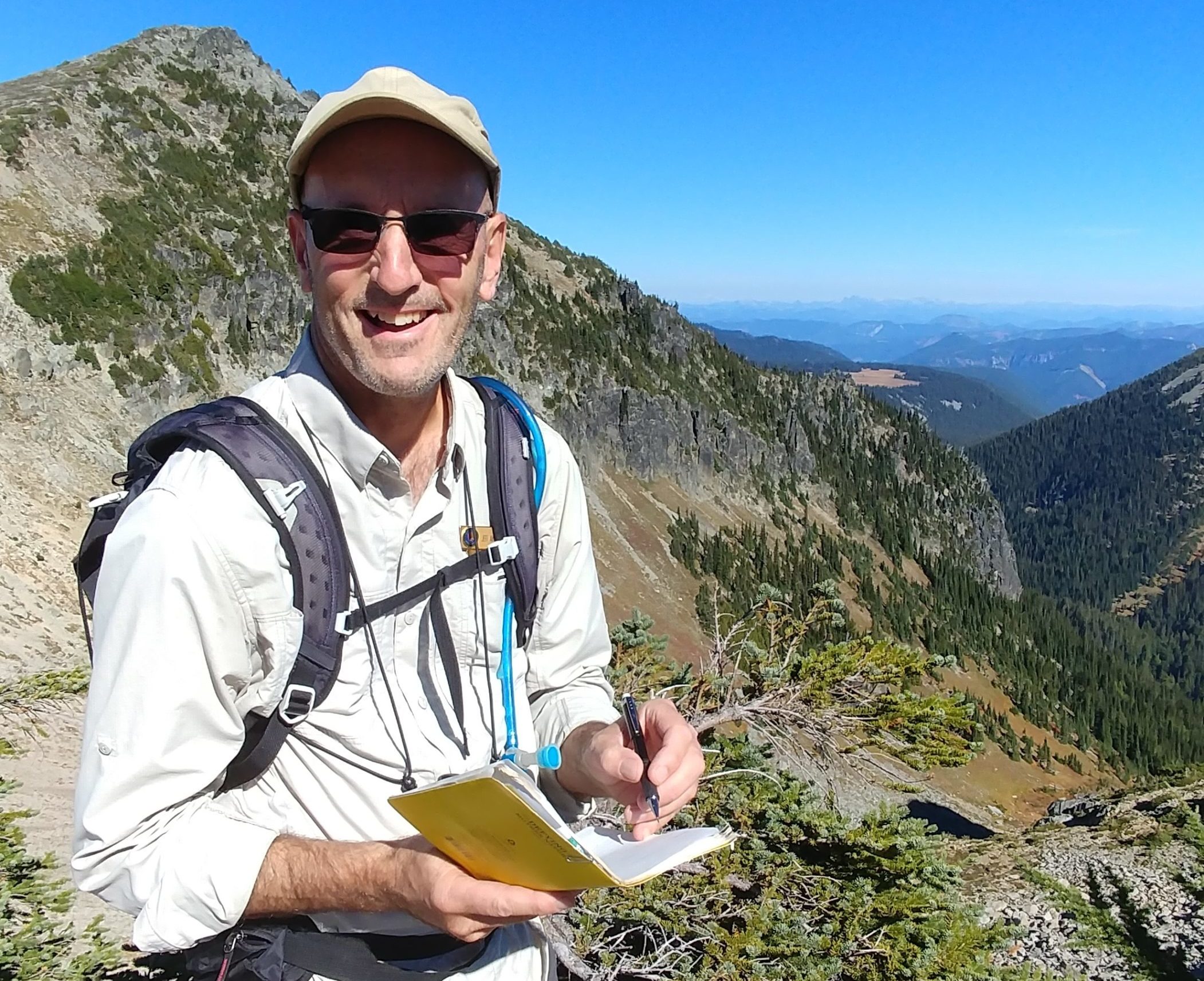 Jeff Antonelis-Lapp in ball cap and sunglasses on a sunny hike