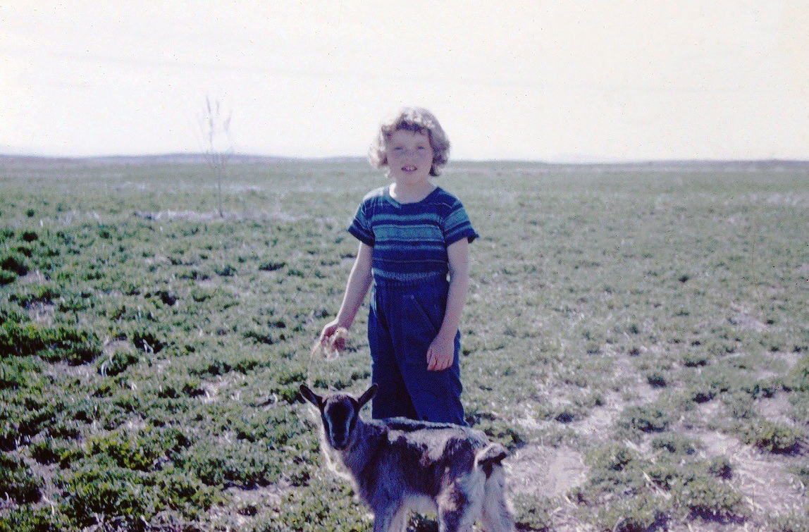 photo of a young Lingscheit daughter standing with a goat in a field