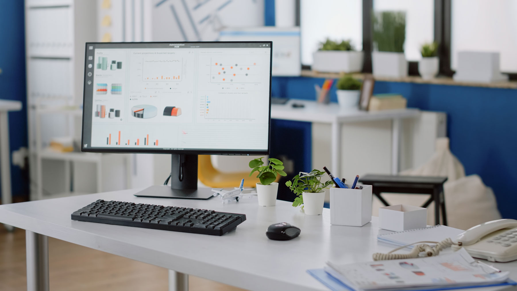 Office setting with computer on desk that includes data visualization dashboards